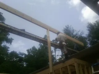 Carpenter setting a ridge beam over a new addition frame — Ice Dam Removal by Roofing Brothers in Ninety Six