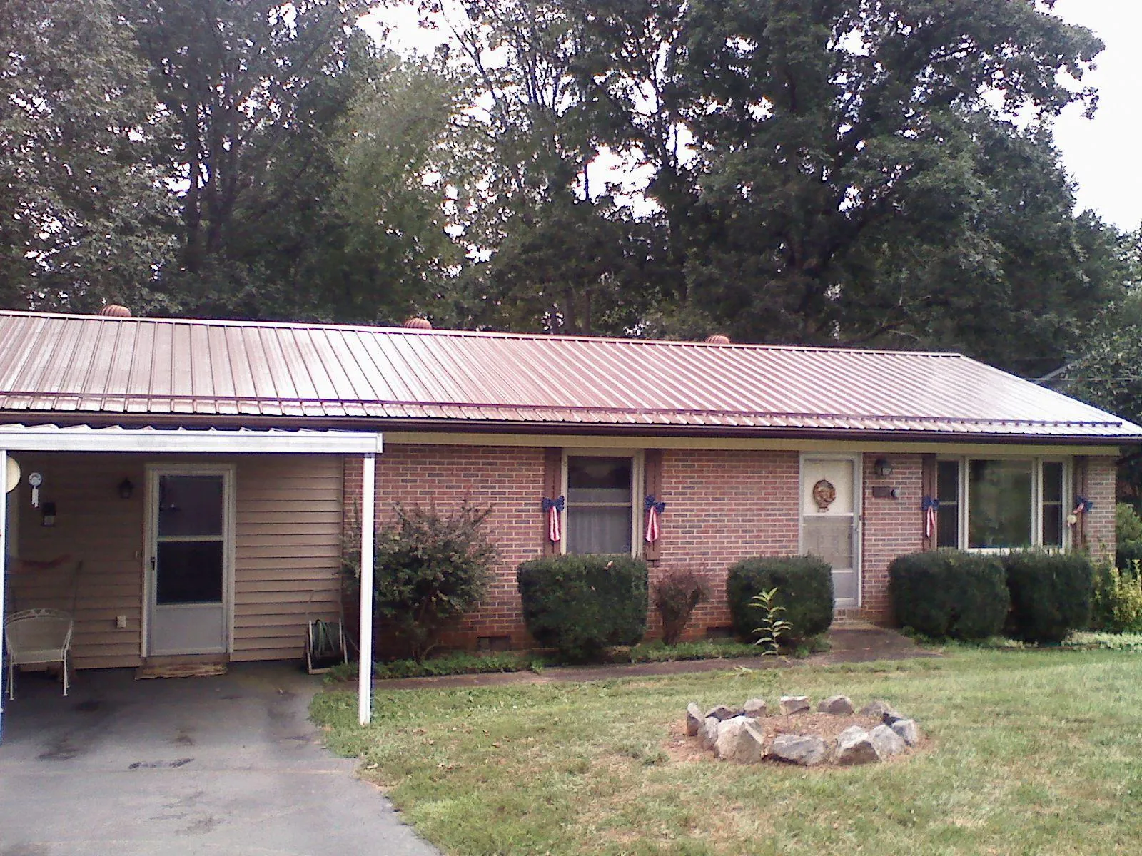 Bronze metal roof and carport on a brick ranch home — Roof Repair work by our crew in Ninety Six