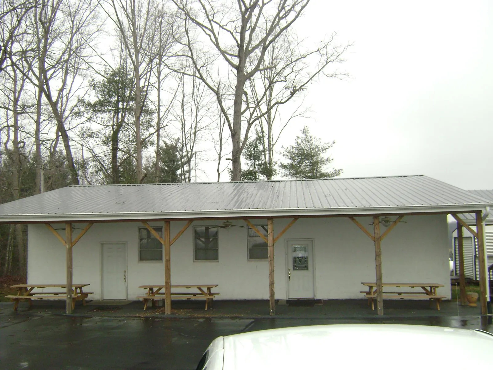 Gray metal roof over a block building with a timber post porch in Ninety Six